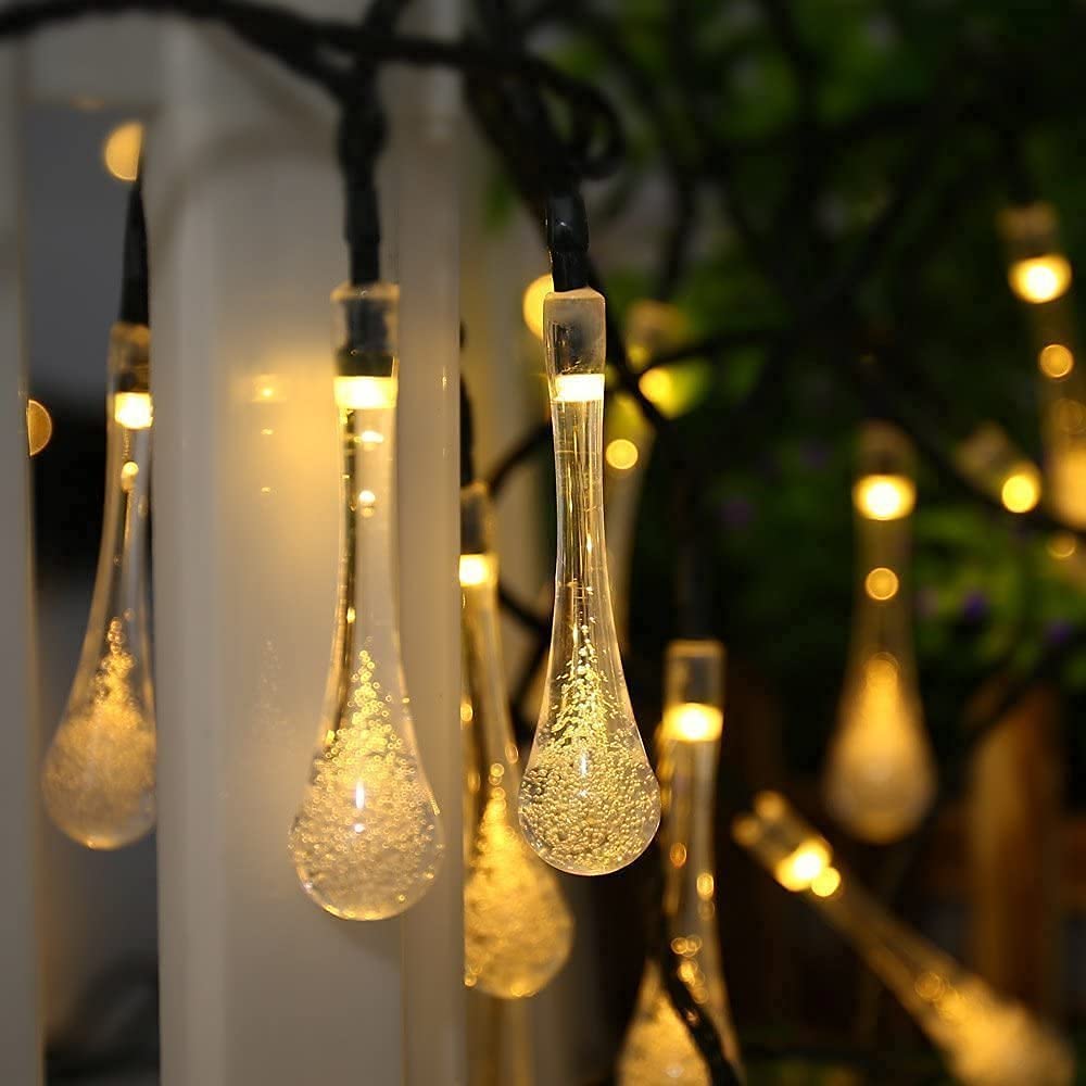 Crystal Drop String LED Lights glowing warmly among greenery