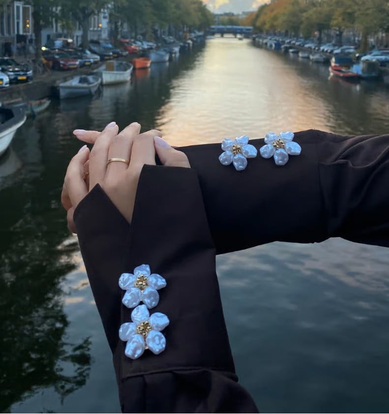 Flower button covers styled on black blouse cuffs